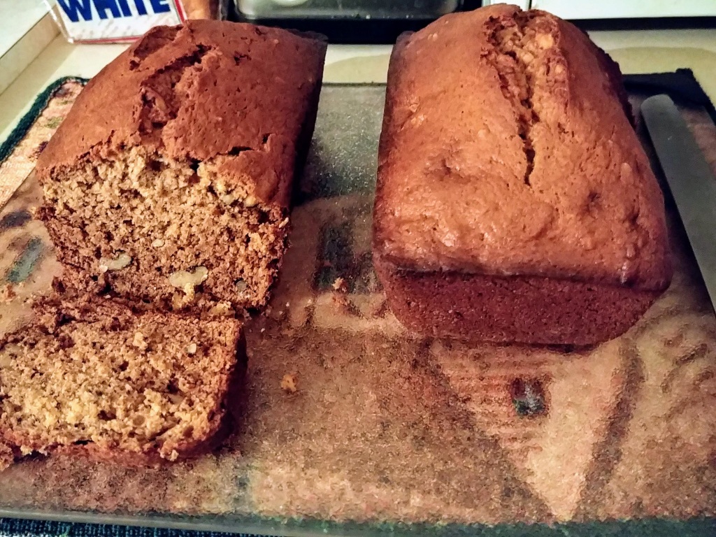 Two loaves of Banana Nut Bread on glass cutting board